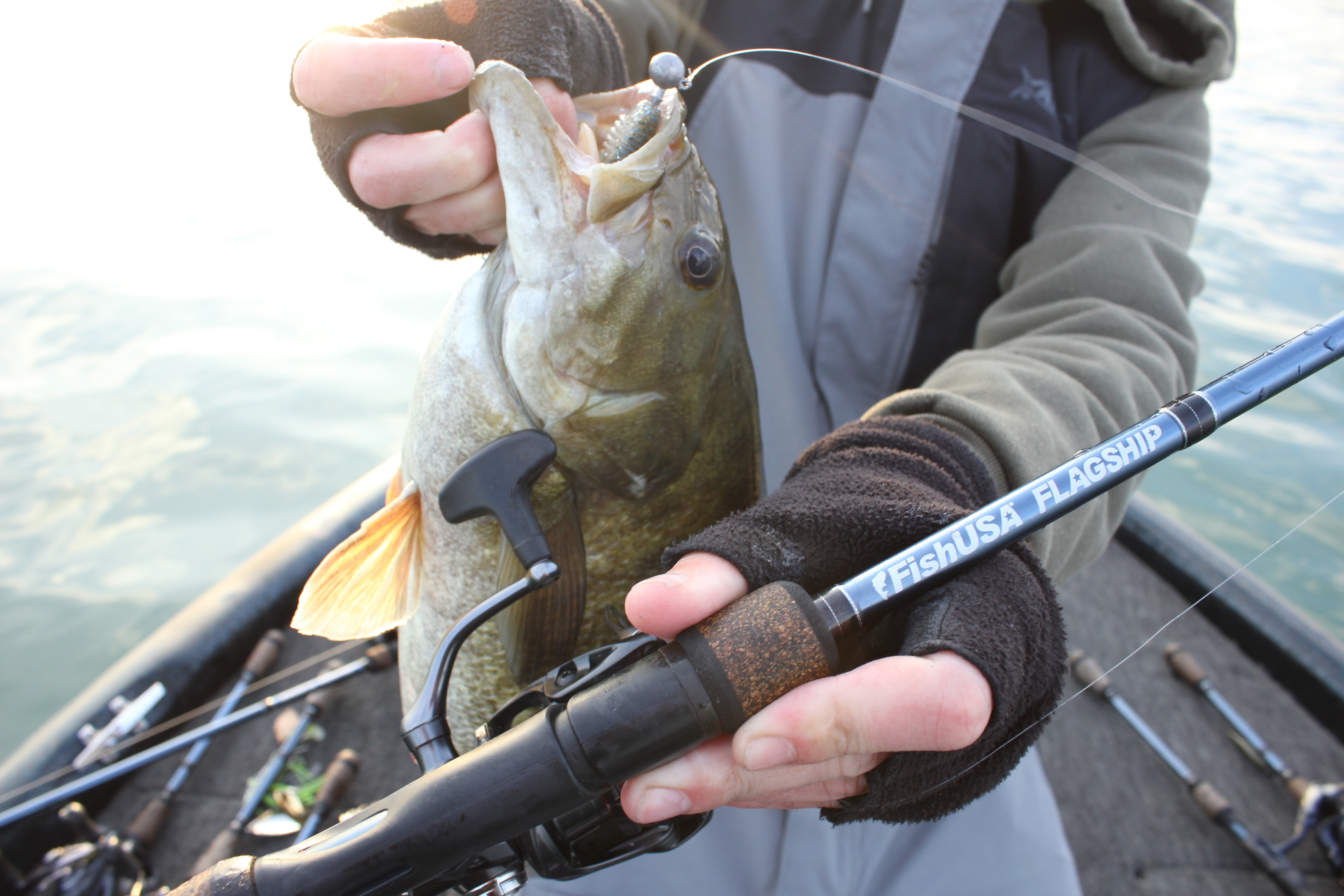 7'6" medium light moderate fast FishUSA Flagship Bass Spinning Rod with a smallmouth bass caught on a Keitech Fat Swing Impact Swimbait